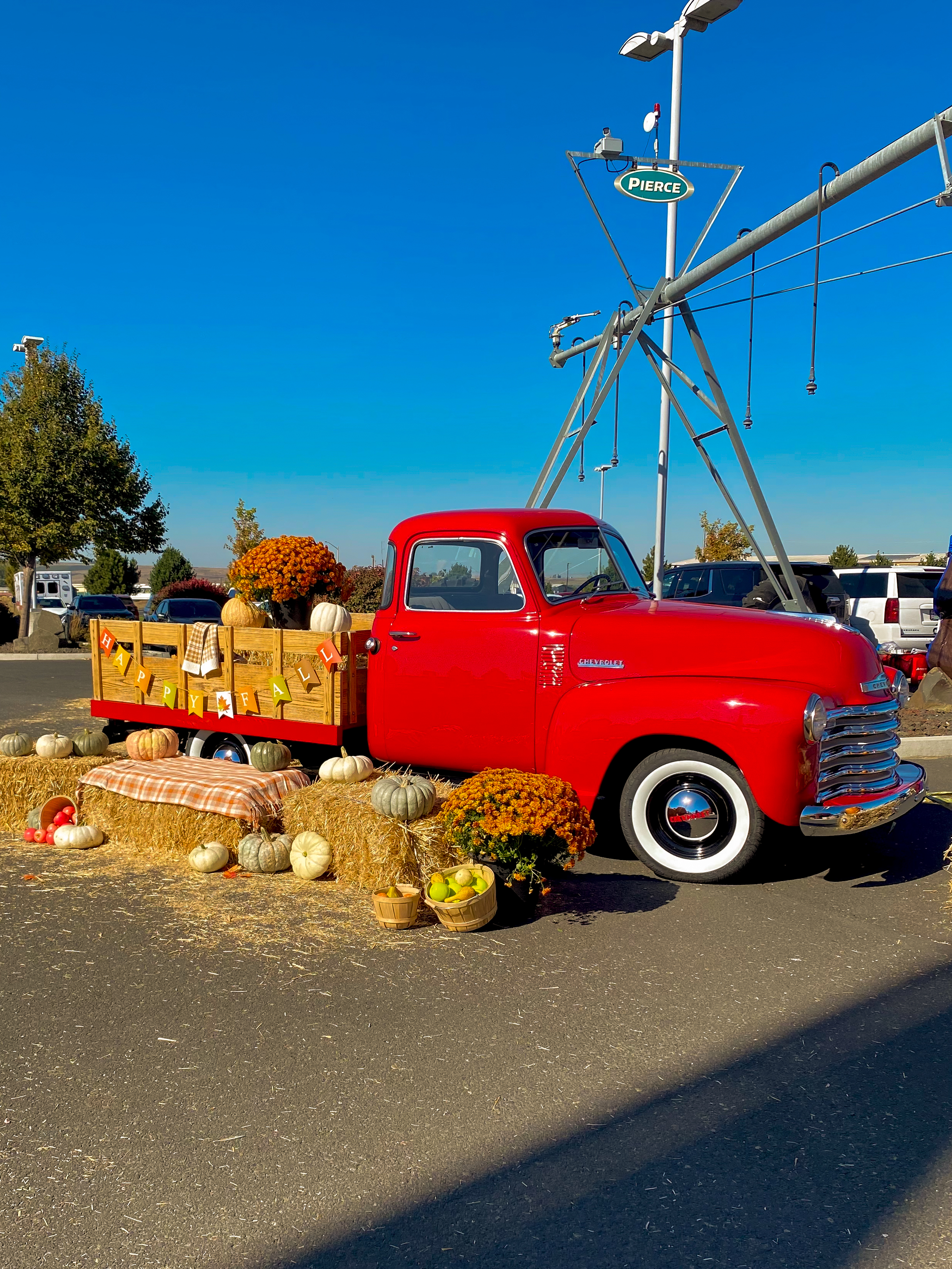 Red truck surrounded by bale hay and pumkins